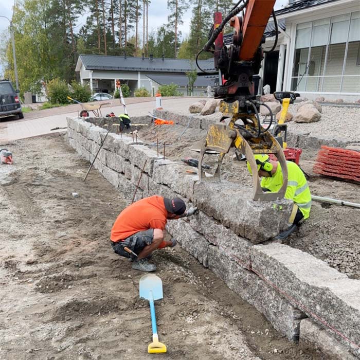 Piharakentajat rakentamassa kiviaitaa omakotitalon pihalle